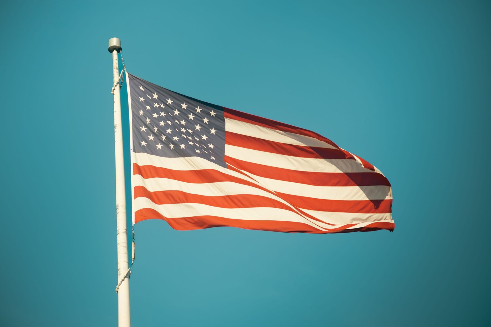 American flag flying against a bright blue sky, symbolizing freedom and patriotism.