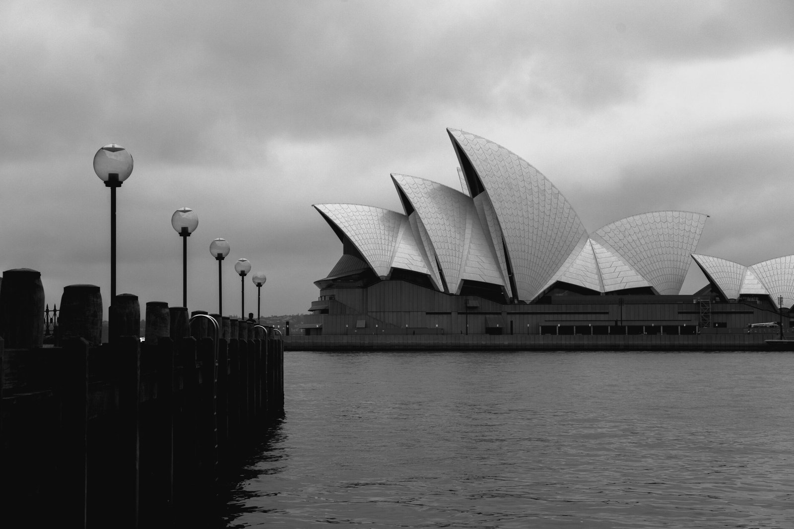 Black and white geometrical facade of modern Sydney Opera House in expressionism style located on embankment on cloudy day